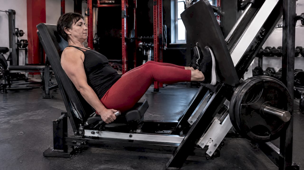 Woman using a seated leg press machine
