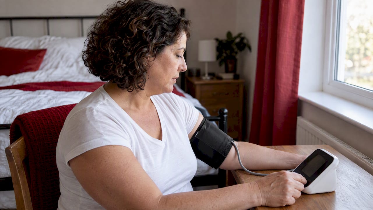 Woman checking blood pressure at home